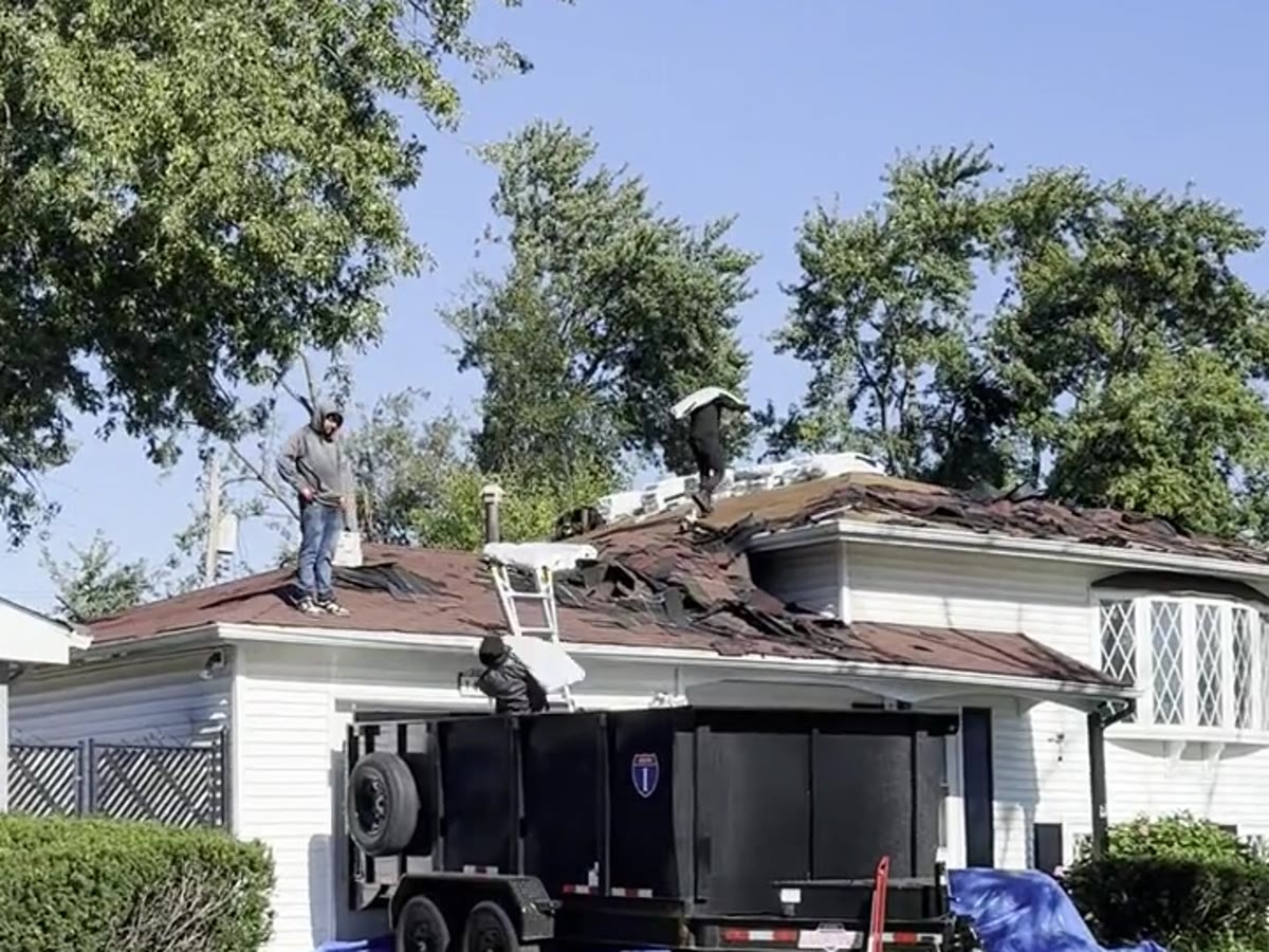 Roof tear-off with crew installing a new roof